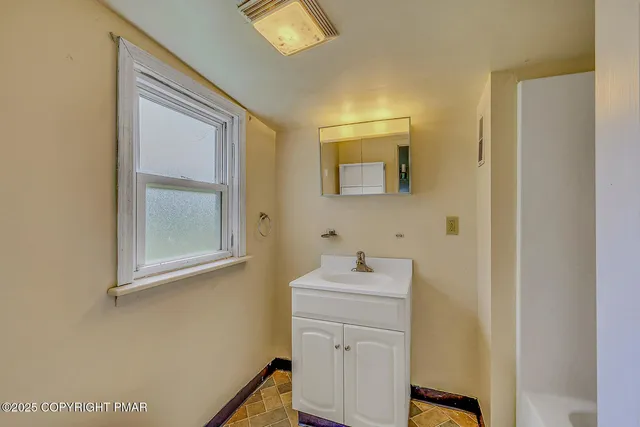a bathroom with a sink a toilet and shower curtain