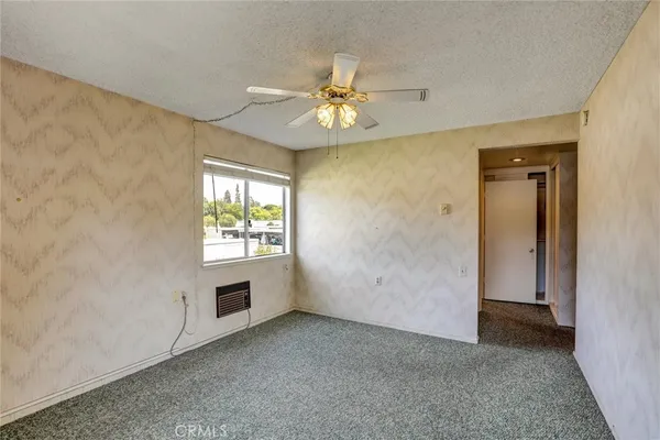 an empty room with windows and fan