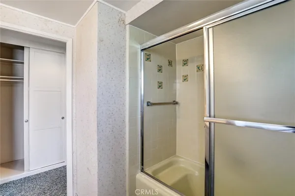 a view of a hallway with wooden floor and a bathroom