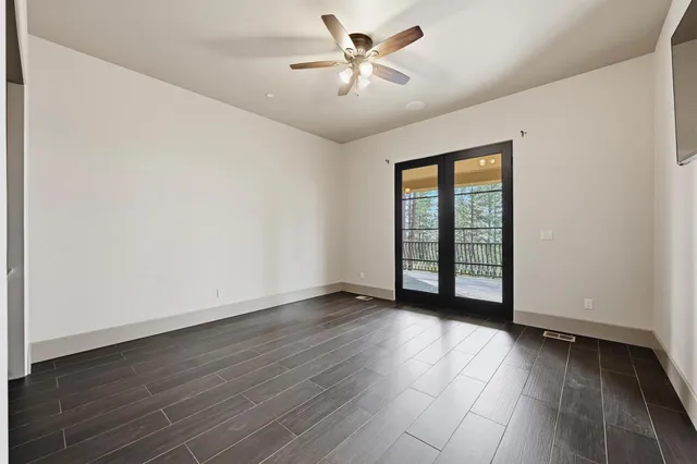 a view of a tennis ground with large trees