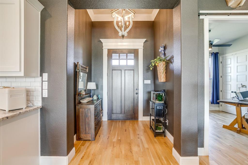 116 Aviara Ridge Road Poolville, TX 76487 - Photo 8 of 38 a view of a hallway with wooden floor and a living room