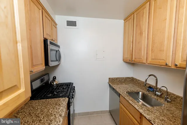 a kitchen with stainless steel appliances granite countertop a sink stove and cabinets