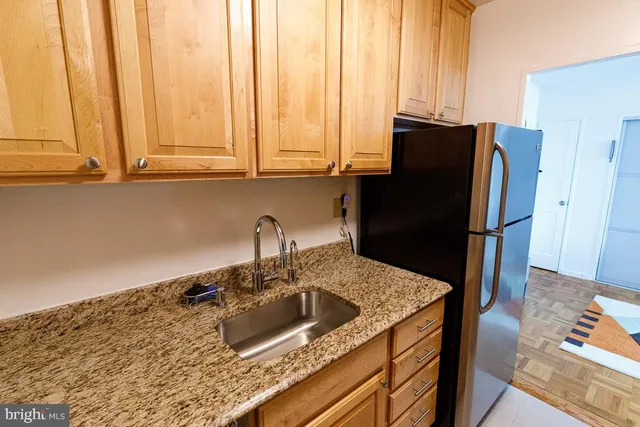 a kitchen with stainless steel appliances granite countertop a sink a refrigerator and a stove