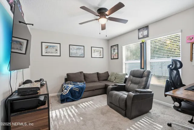 a living room with furniture a window and a flat screen tv