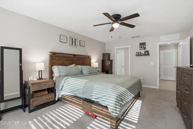 a bedroom with a bed and a ceiling fan