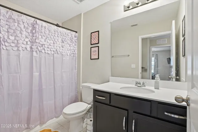 a bathroom with a double vanity sink toilet and a mirror