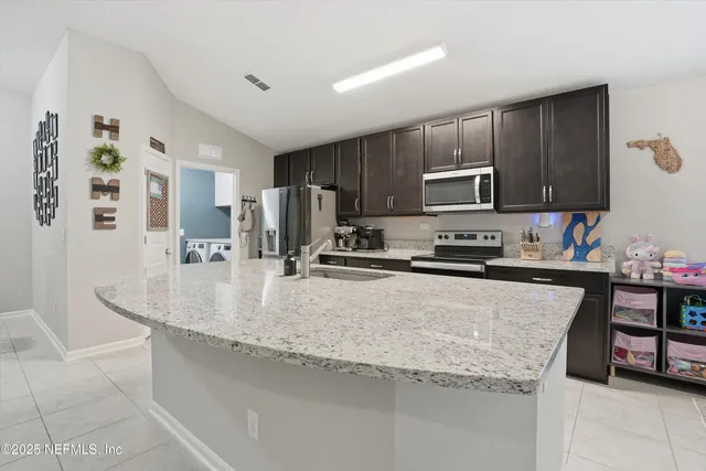 a kitchen with stainless steel appliances granite countertop a sink refrigerator and cabinets