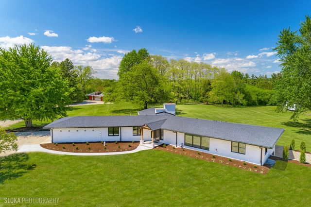 a view of a big house with a big yard and large trees