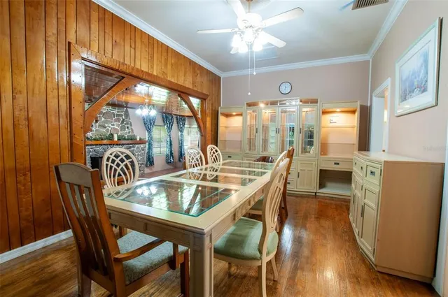 a dining room with furniture a chandelier and wooden floor
