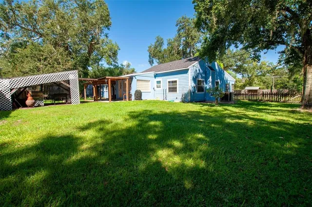 a view of a house with a big yard and large trees
