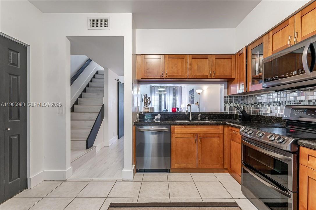 3310 Concert Lane, Unit 129 Margate, FL 33063 - Photo 2 of 5 a kitchen with stainless steel appliances granite countertop a stove microwave and cabinets