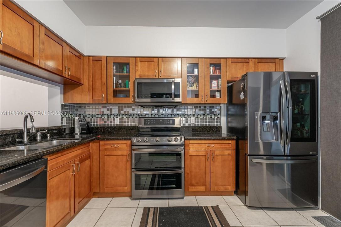 3310 Concert Lane, Unit 129 Margate, FL 33063 - Photo 3 of 5 a kitchen with stainless steel appliances granite countertop a refrigerator and a sink