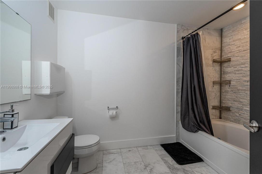 3310 Concert Lane, Unit 129 Margate, FL 33063 - Photo 4 of 5 a bathroom with a sink a toilet and shower