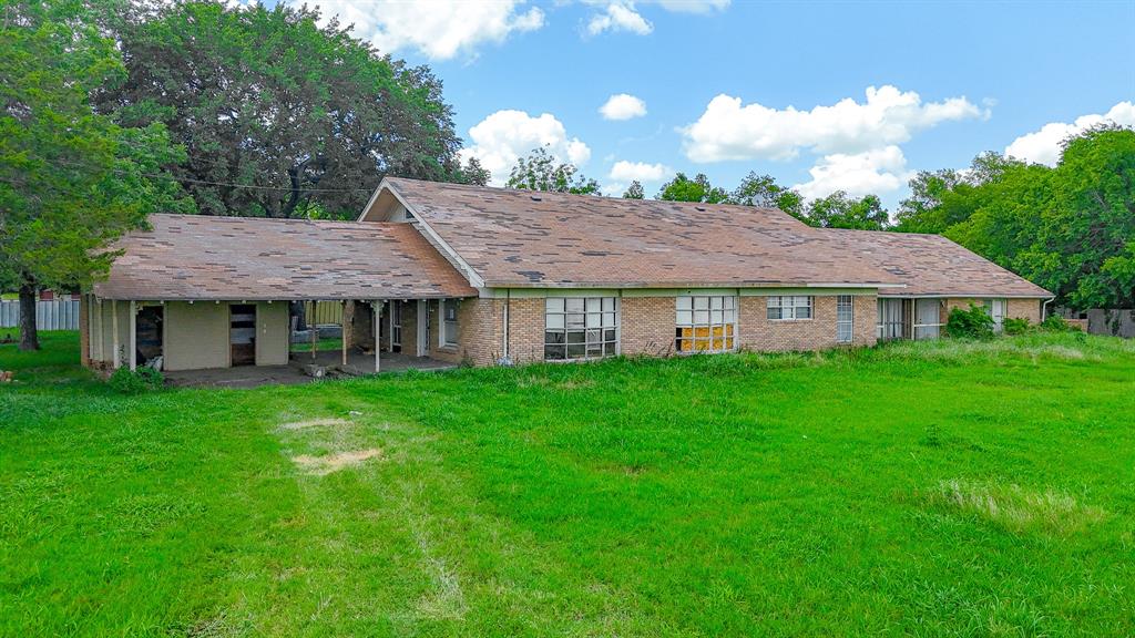 a view of a house with a yard balcony and wooden fence