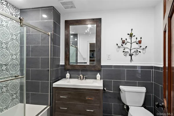 a kitchen with stainless steel appliances kitchen island granite countertop a refrigerator a stove a sink dishwasher and white cabinets with wooden floor