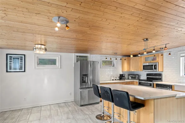 a kitchen with stainless steel appliances granite countertop a sink a stove a refrigerator a washer dryer and white cabinets