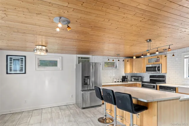 a kitchen with stainless steel appliances granite countertop a sink a stove a refrigerator a washer dryer and white cabinets