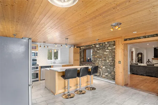 a kitchen with stainless steel appliances kitchen island granite countertop a refrigerator and a stove top oven