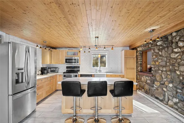 a large white kitchen with a sink and large windows