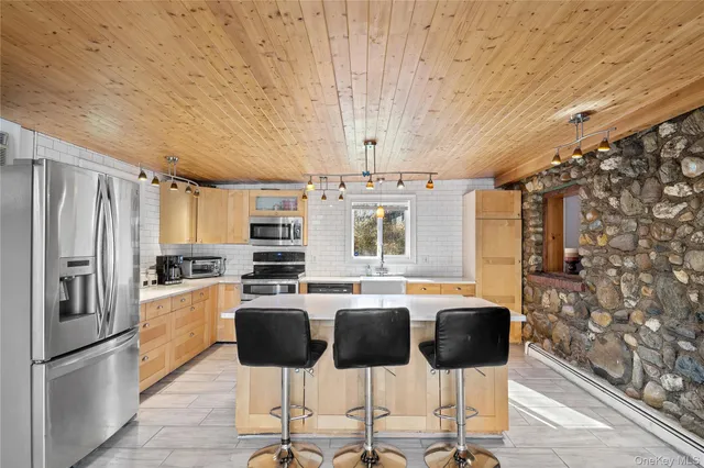 a large white kitchen with a sink and large windows