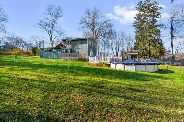 a view of a back yard of the house with green space and porch area