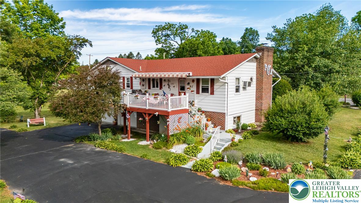 678 Interchange Road Kresgeville, PA 18333 - Photo 6 of 45 A well-maintained home featuring a welcoming deck, surrounded by verdant landscaping and mature trees.