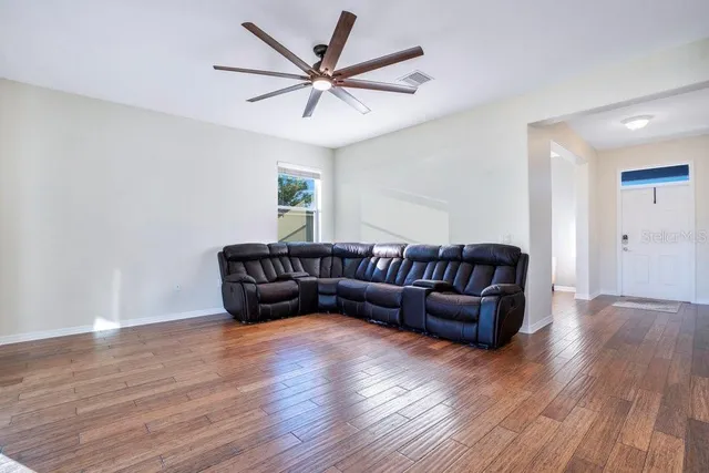 a living room with couches and a wooden floor