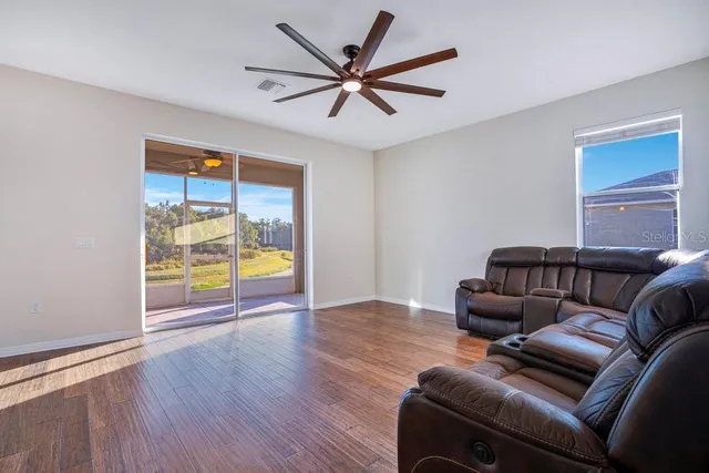 a living room with furniture a ceiling fan and a window