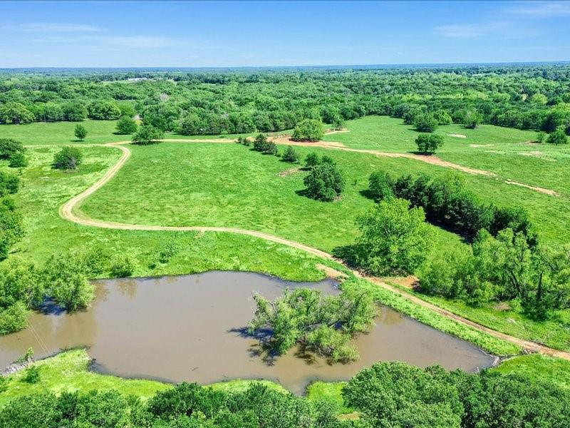 1747 Desvoignes Road Denison, TX 75021 - Photo 31 of 40 an aerial view of a grassy field with trees in the background