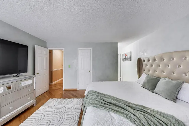 a bedroom with a large bed and a flat screen tv