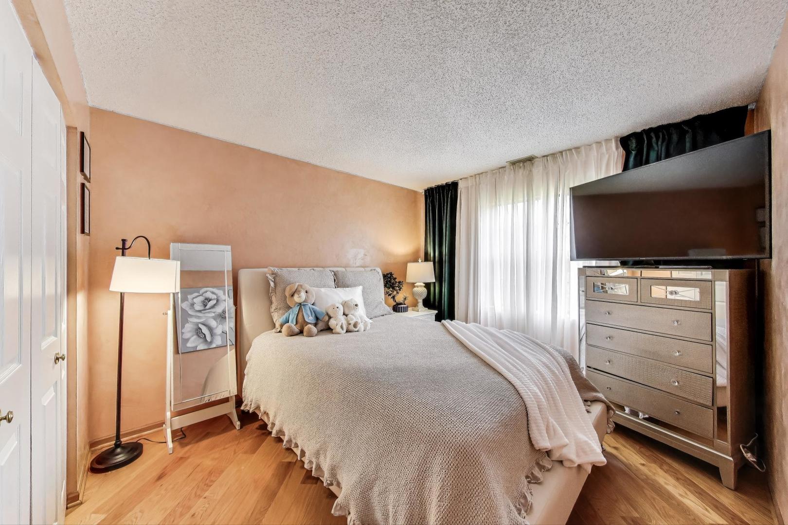 738 Hapsfield Lane, Unit 7A2 Buffalo Grove, IL 60089 - Photo 20 of 29 a bedroom with a bed and a flat screen tv