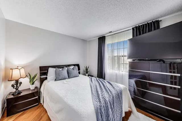 a bedroom with a bed and wooden floor