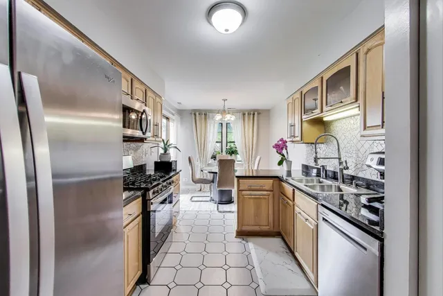 a kitchen with stainless steel appliances a sink stove refrigerator and cabinets