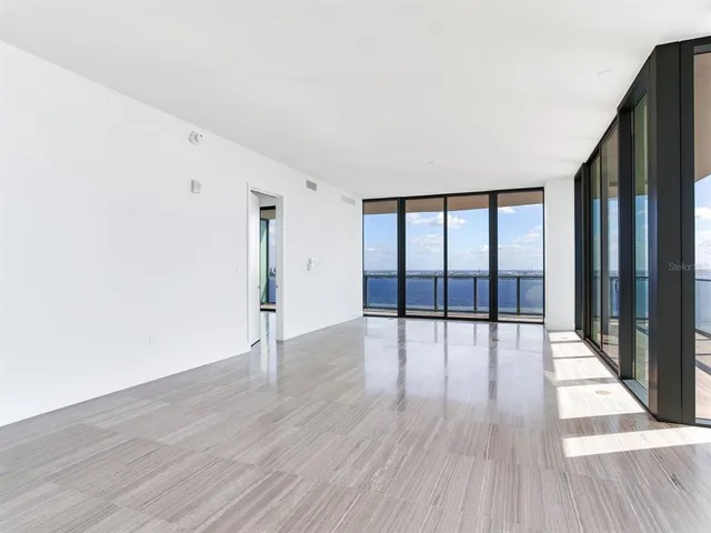 a view of a living room hardwood floor and a large window