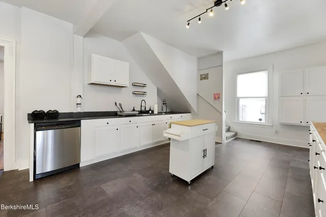 a kitchen with granite countertop white cabinets and white appliances