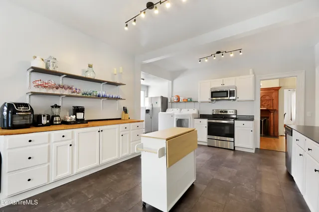a large white kitchen with stainless steel appliances