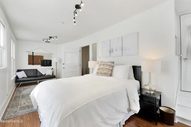 a bedroom with a bed and wooden floor