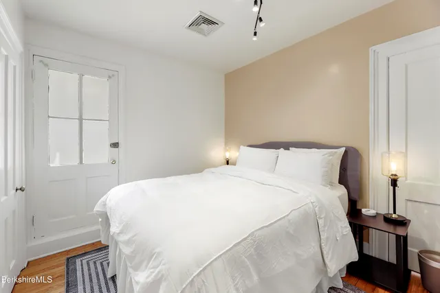 a bedroom with a bed and wooden floor