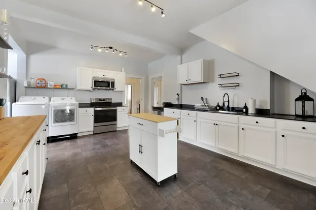 a kitchen with cabinets a sink and white stainless steel appliances