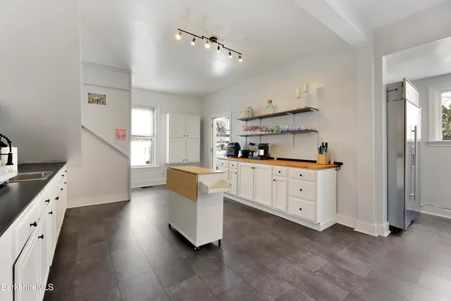 a kitchen with white cabinets and white appliances