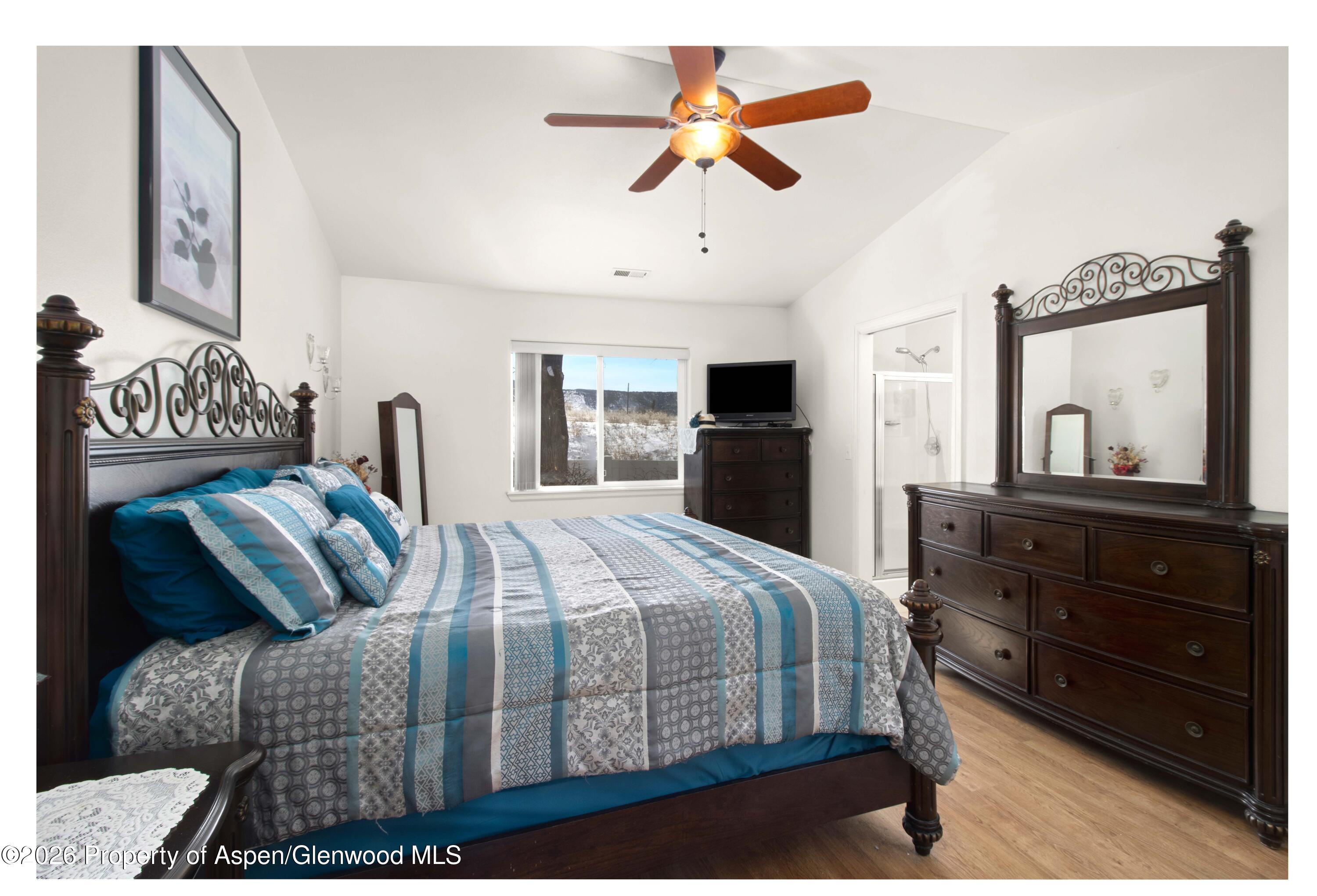 256 Cliff View Circle Parachute, CO 81635 - Photo 9 of 20 a bedroom with a large bed and a chandelier