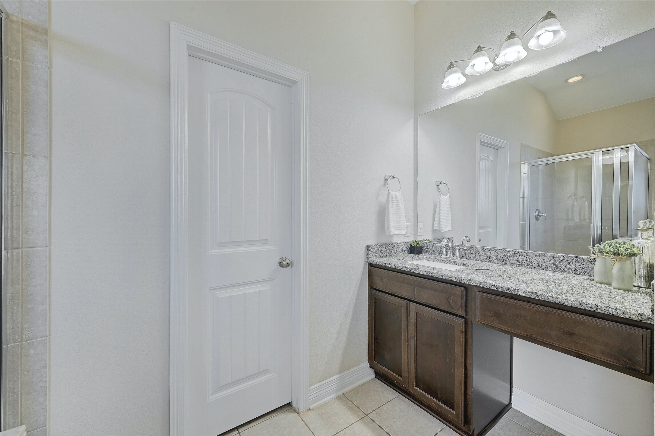 18512 Tanner Bayou Loop Austin, TX 78738 - Photo 11 of 32 a bathroom with a granite countertop double vanity sink a mirror and a shower