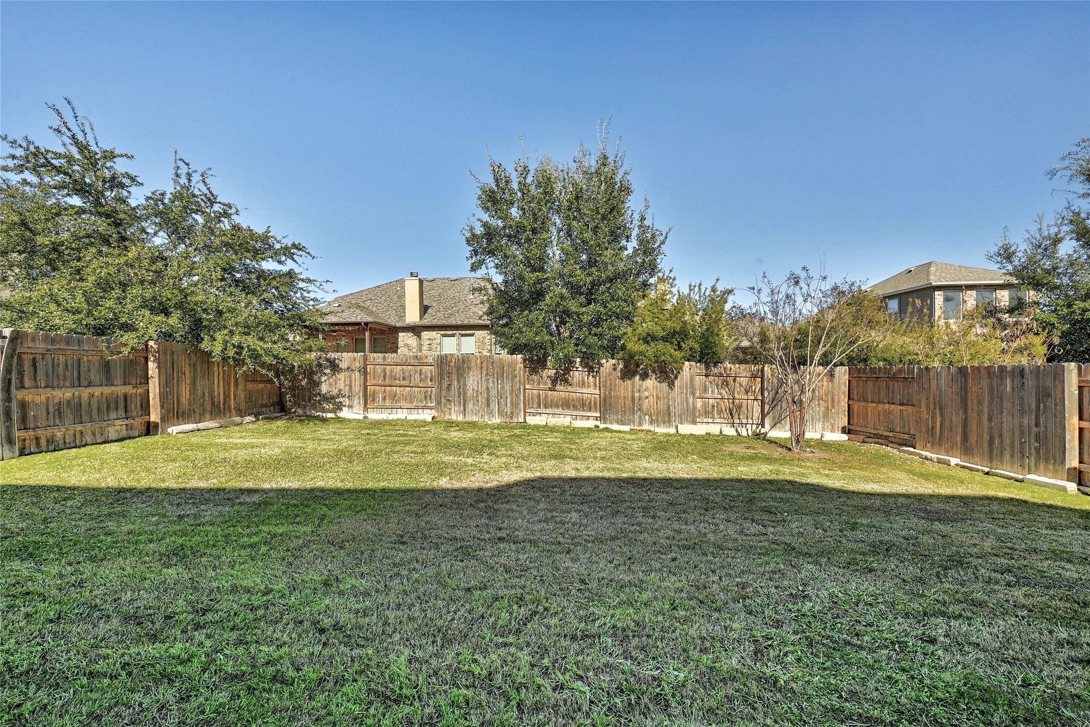 18512 Tanner Bayou Loop Austin, TX 78738 - Photo 21 of 32 a view of a house with a yard and a large tree