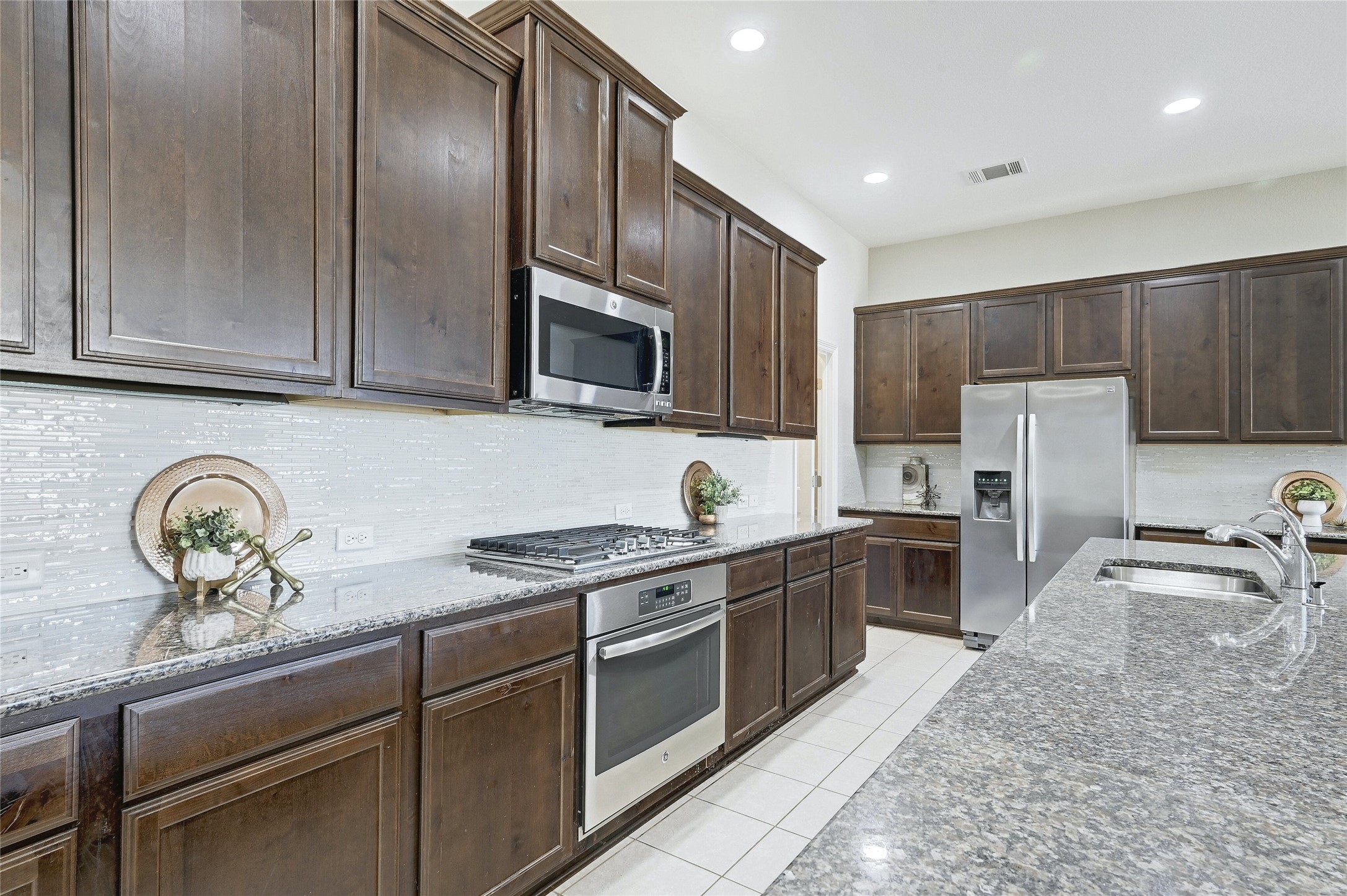 18512 Tanner Bayou Loop Austin, TX 78738 - Photo 4 of 32 a kitchen with stainless steel appliances granite countertop a sink stove and refrigerator