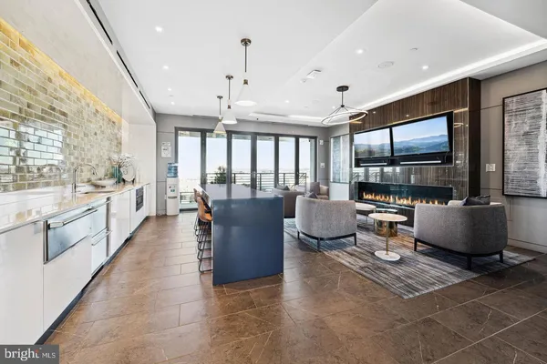 a living room with furniture a large window and stainless steel appliances