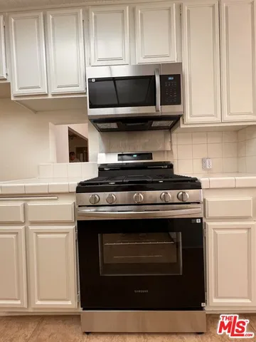 a kitchen with stainless steel appliances granite countertop a stove and a microwave