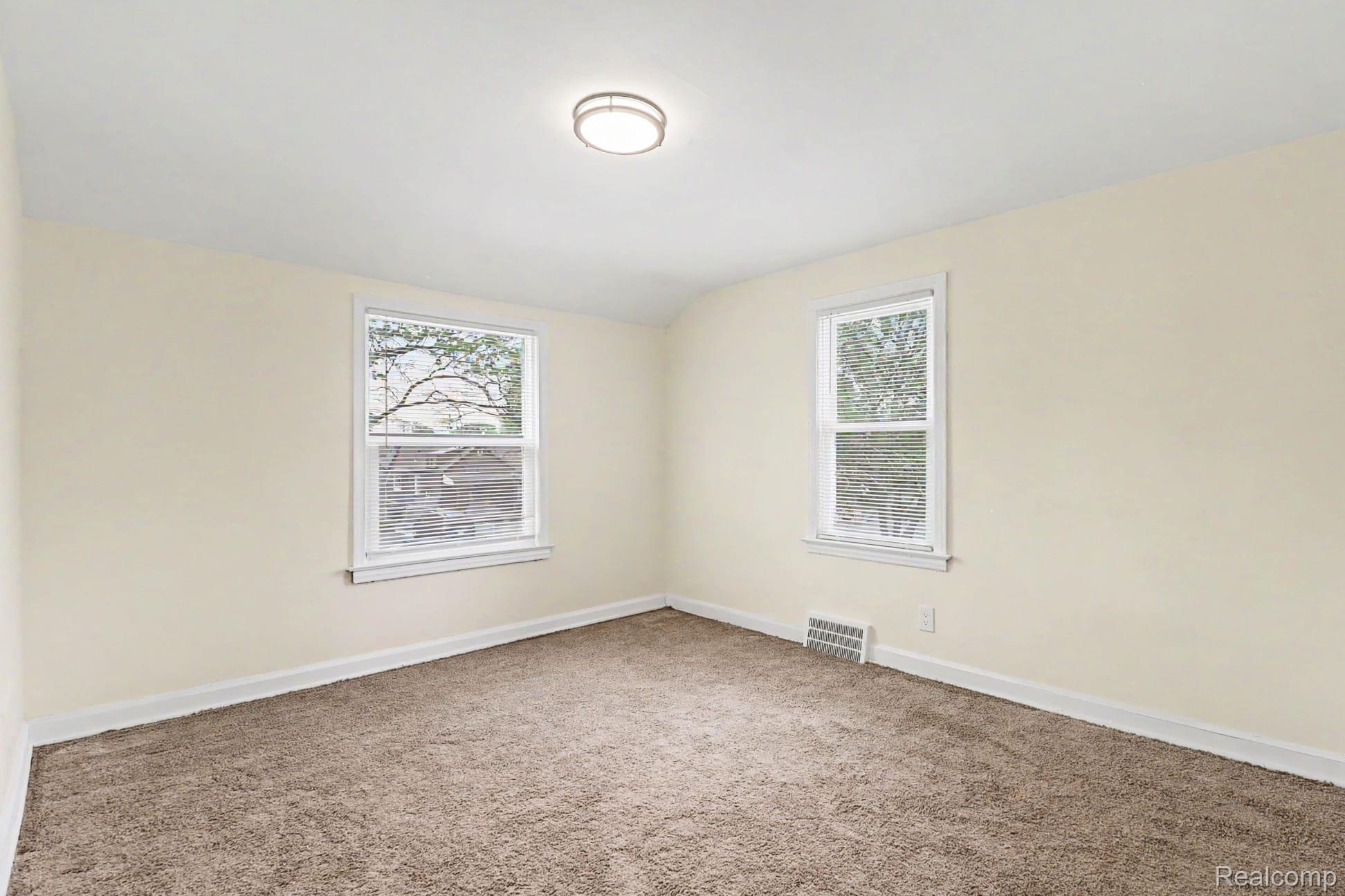 16682 Robson Street Detroit, MI 48235 - Photo 17 of 19 Neutral-toned walls and plush carpeting in this bright room