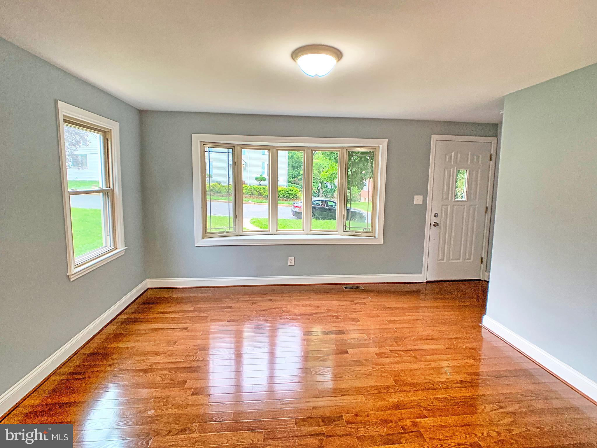 3607 Telmar Road Baltimore, MD 21207 - Photo 3 of 19 a view of an empty room with window and wooden floor