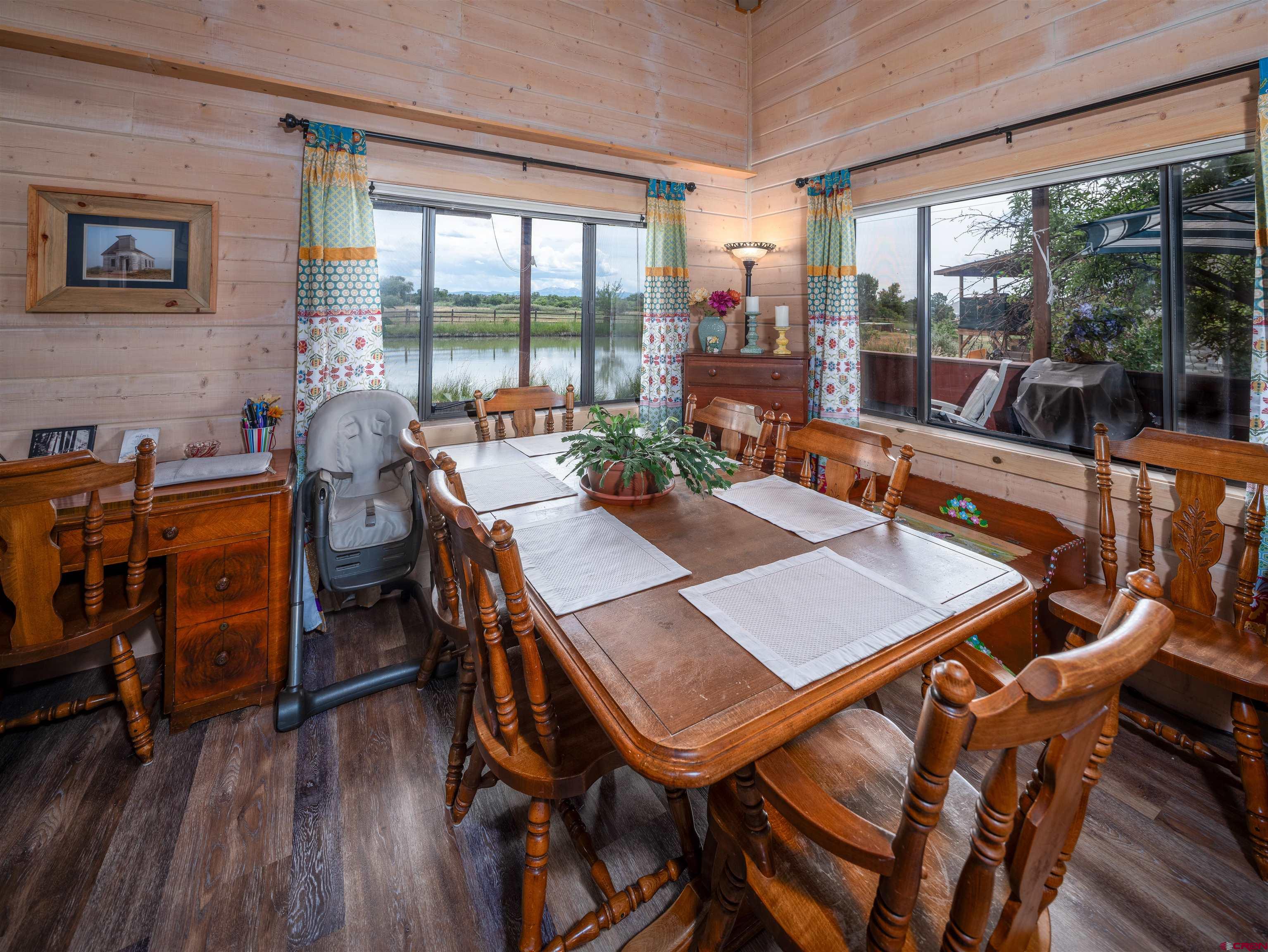 25901 Rd T Dolores, CO 81323 - Photo 42 of 45 a view of a dining room with furniture large windows and wooden floor