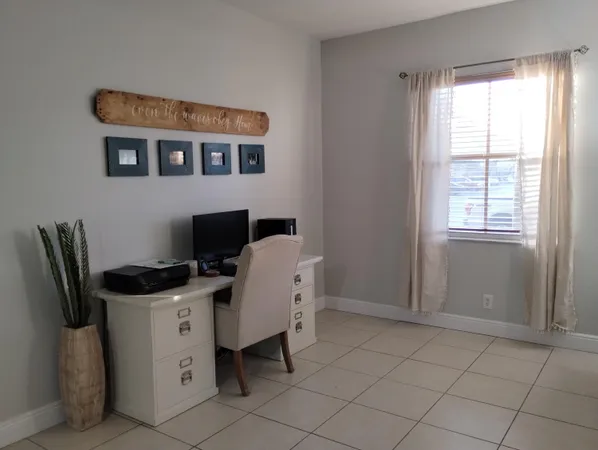 a view of a workspace with furniture and a window